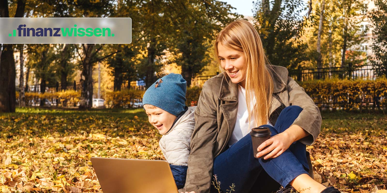 Junge Frau sitz mit Sohn am Laptop im Laub