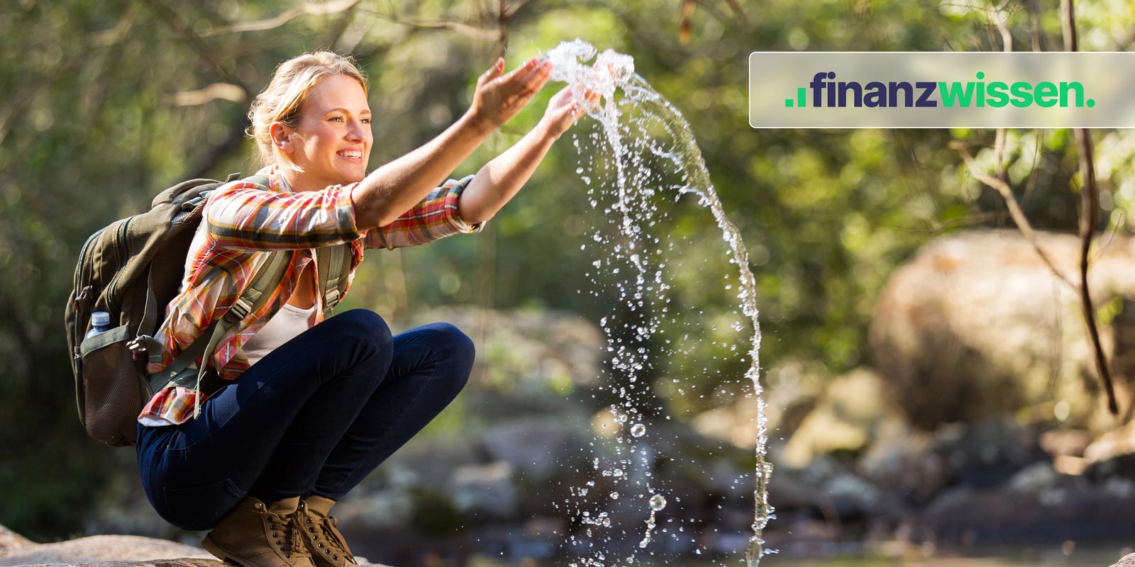 Wanderin hebt Wasser aus kleinem Bach im Wald hoch.